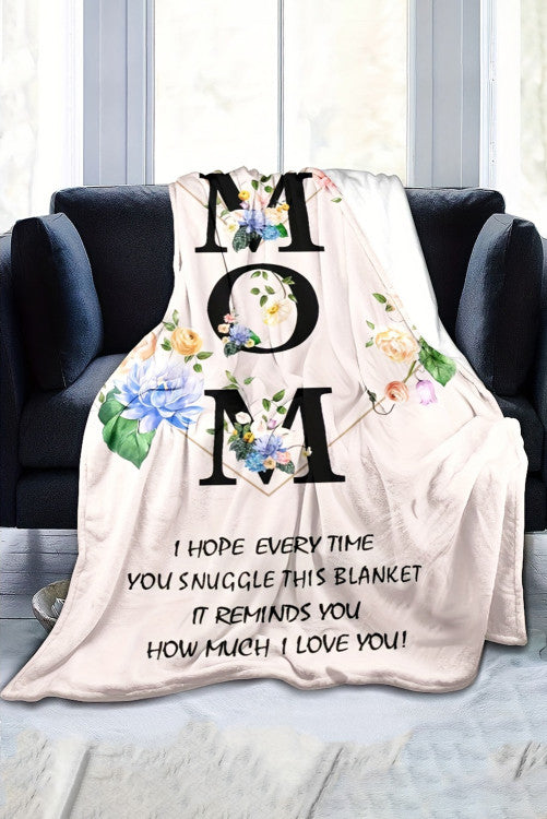 Blanket with floral design and text on a couch